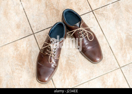 Marrone di Moda scarpe uomo su un marrone chiaro le piastrelle di ceramica, vista da sopra Foto Stock