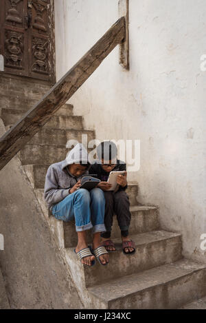 Due giovani ragazzi adolescenti rapiti il loro computer compresse a Kathmandu, Nepal. Foto Stock