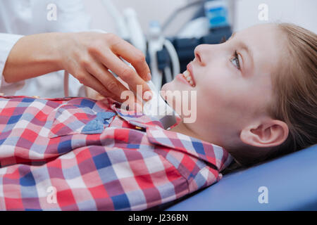 Happy girl getting collo ad ultrasuoni la scansione in clinica Foto Stock