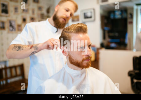 Ricezione maschio capelli barba di trattamento in un barbiere Foto Stock