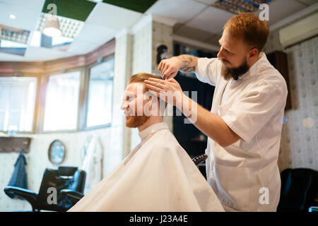 Ricezione maschio capelli barba di trattamento in un barbiere Foto Stock