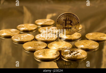 Pila di bitcoins su fondo oro - cyber moneta e cryptocurrency token virtuale Foto Stock