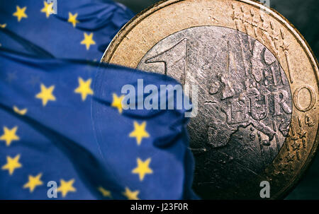 Monete in euro tra due bandiere europee Foto Stock