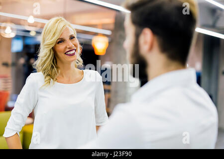 Bella commessa a parlare con il cliente e sorridente Foto Stock