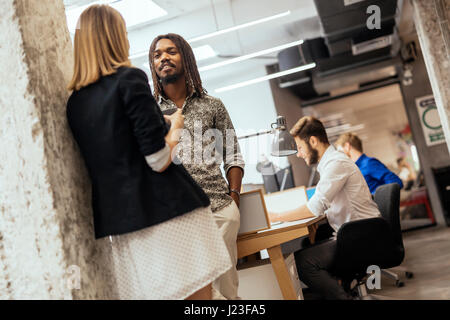 Colleghi di lavoro che parlano in un ufficio Foto Stock