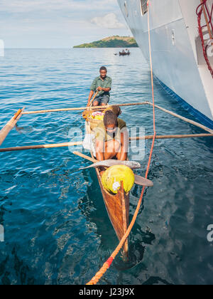 Hell-Ville, Madagascar - 19 Dicembre 2015 : malgascio fornitori da loro canoe outrigger offrono pesce e frutti tropicali di nave passeggeri presso Hell-Vill Foto Stock