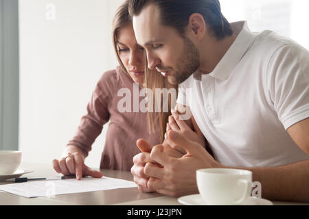 Grave coppia sposata con documenti, considerando l'offerta di prestito, calc Foto Stock