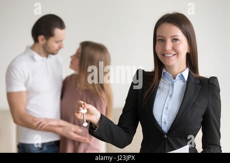 Attraente agente immobiliare tenendo premuto i tasti per appartamento, proprietà Foto Stock