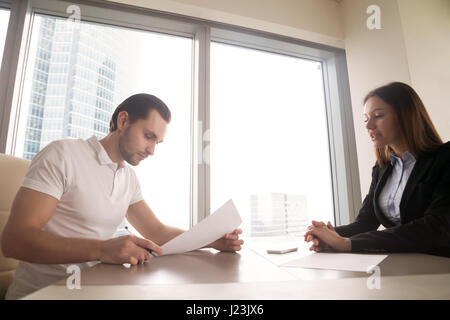 Ottenuto un lavoro. Giovane uomo pronto a firmare contratti di lavoro Foto Stock