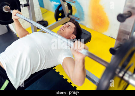 Uomo bello il sollevamento pesi in palestra e stare in forma Foto Stock