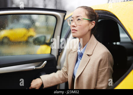 Donna Moderna in eleganti vestiti in uscita della macchina Foto Stock