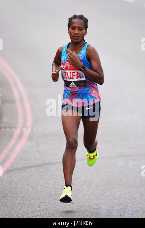 Tigist Tufa che corre alla Virgin London Marathon del 2017 dopo aver attraversato il Tower Bridge e accanto alla Torre di Londra, Regno Unito Foto Stock