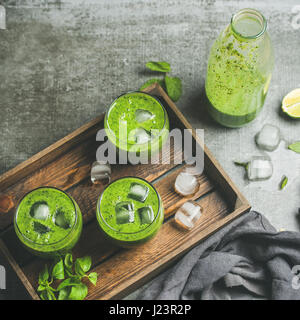 Frullato fresco con cubetti di ghiaccio e menta, calce su sfondo grigio Foto Stock