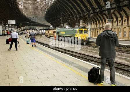 Appassionato di rampa a fotografare un Freightliner classe diesel 66 loco presso la stazione di York, Regno Unito Foto Stock