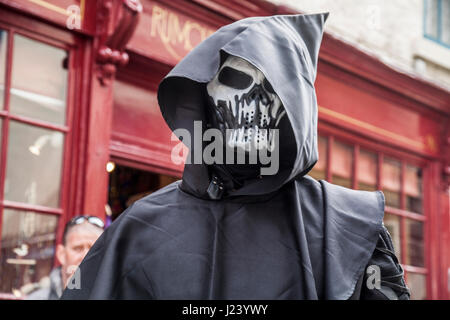 Un uomo vestito con un abito con cappuccio e maschera di scheletro a Whitby Goth celebrazioni di fine settimana nel North Yorkshire, Inghilterra, Regno Unito Foto Stock