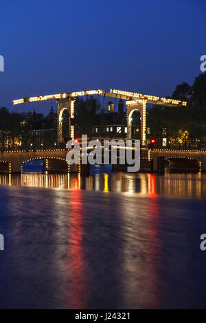 Magere Brug (ponte Magere) e il fiume Amstel al crepuscolo, Amsterdam, Paesi Bassi Foto Stock