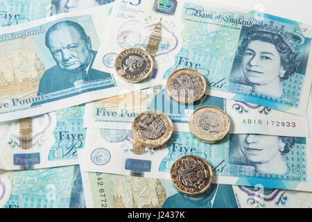 New British £1 monete su uno sfondo di UK £ 5 pound note Foto Stock