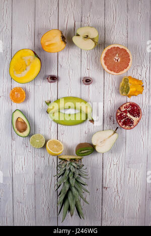 Un assortimento di frutta dimezzata collocato in un cerchio la realizzazione di una forma di una faccia Foto Stock