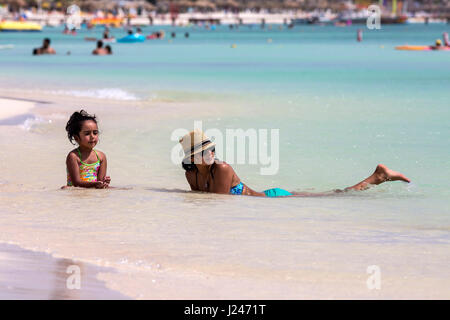 Madre e figlia rilassarsi nel surf di Palm Beach, Aruba. Foto Stock