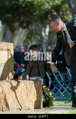 Guildford, Perth, Australia occidentale, Australia. Xxv Aprile, 2017. Uomo e bambino guardando le corone floreali durante Anzac Day service a Guildford, Western Australia. Sheldon Levis/Alamy Live News Foto Stock