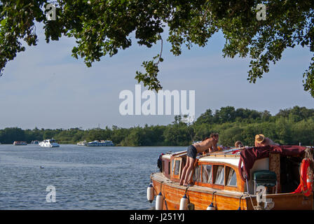 Famiglia rilassanti vacanze in barca sulla Norfolk Broads nella pittoresca Malthouse ampia, Ranworth, Norfolk, Inghilterra, Regno Unito Foto Stock