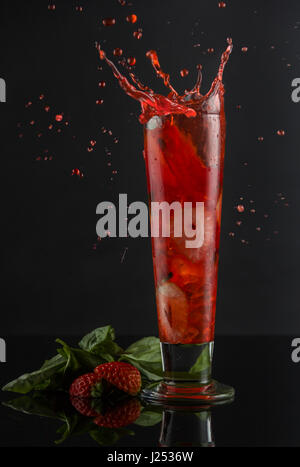 La vodka agitate con fragole fresche e le foglie di basilico, zucchero vanigliato, limone fresco e creme de fraise. Servito in un bicchiere di imbracatura Foto Stock