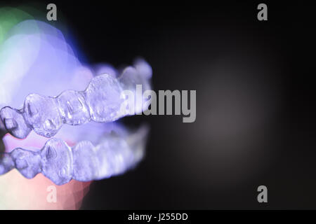 Invisibile ortodonzia dentale su sfondo colorato Foto Stock