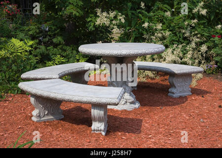 La forma di una mezzaluna seduta panche e tavolo rotondo in cortile paesaggistico giardino in estate, Floressens giardino, Saint-Raymond, Portneuf, Quebec, Canada Foto Stock