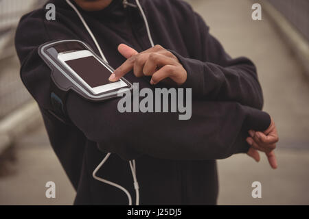 La sezione centrale della donna utilizzando il telefono cellulare Foto Stock