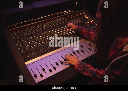 Femmina ingegnere audio con mixer audio in studio di registrazione Foto Stock