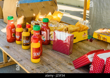 Brakne Hoby, Svezia - 22 Aprile 2017: documentario di piccoli agricoltori pubblica il giorno. Tabella con la senape, ketchup, salsicce e pane di tovaglioli. Foto Stock