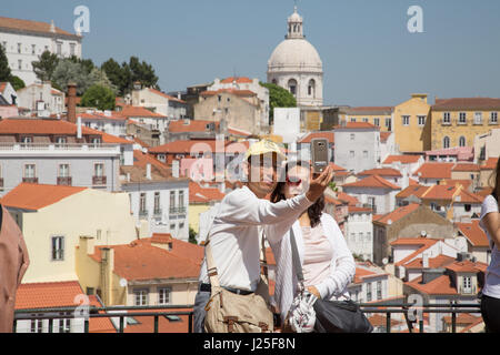 Un paio di prendere una selfie su un telefono cellulare con la città di Lisbona in background. Foto Stock
