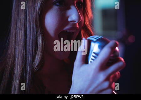 Close-up del cantante femminile a cantare in studio di registrazione Foto Stock