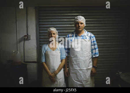 Ritratto di sesso maschile e lavoratori di sesso femminile in piedi nella fabbrica di apicoltura Foto Stock