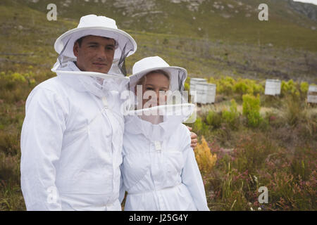 Ritratto di fiducioso maschio e femmina gli apicoltori a apiario Foto Stock