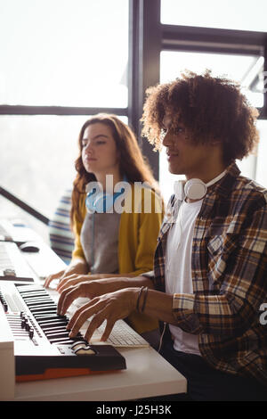 I tecnici audio riproduzione di tastiera elettrica in studio di registrazione Foto Stock