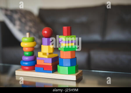 Close-up di impilamento colorati giocattolo sul tavolo nel salotto di casa Foto Stock