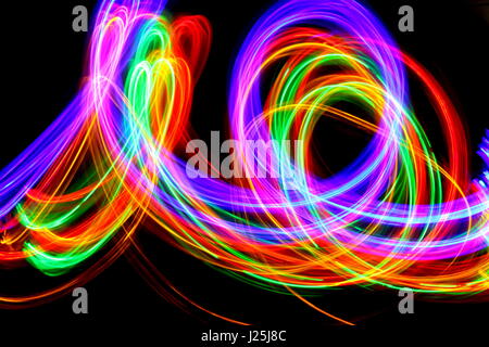 Una lunga esposizione fotografia di neon multi-colore in un modello astratto contro uno sfondo nero. Luce fotografia pittura, di colore in astratto Foto Stock