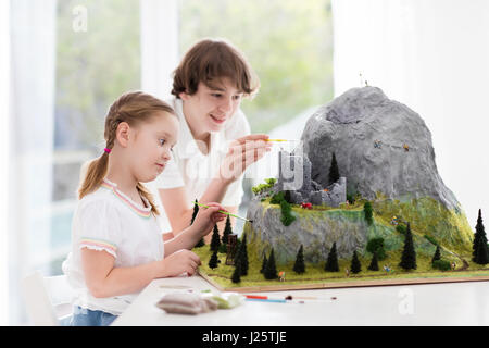 I bambini lavorano per la costruzione del modello Progetto scuola. I bambini costruiscono in miniatura Modello scala di montagna per la geografia della classe. Attività extrascolastiche e hobby cl Foto Stock