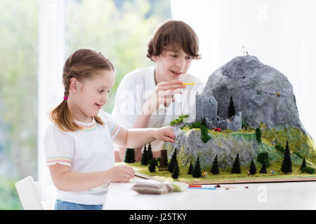 I bambini lavorano per la costruzione del modello Progetto scuola. I bambini costruiscono in miniatura Modello scala di montagna per la geografia della classe. Attività extrascolastiche e hobby cl Foto Stock