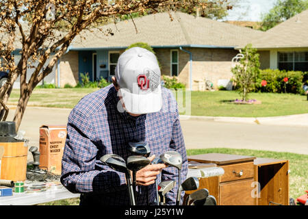 Un anziano uomo caucasico guarda al golf club a una vendita di garage in Oklahoma City, Oklahoma, Stati Uniti d'America. Foto Stock