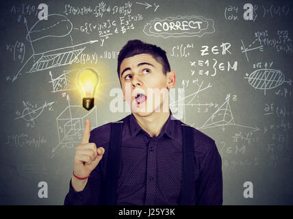 Smart studente brillante idea lampadina e scuola di Alta Matematica e scienze formule su sfondo blackboard Foto Stock
