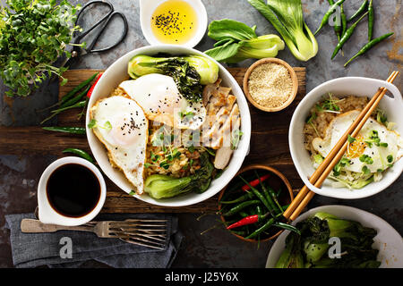 Cibo asiatico concetto con riso fritto, baby bok choi, uova e salsa di soia Foto Stock