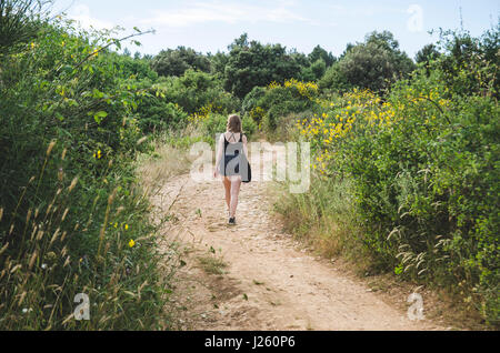 Giovane donna camminare lungo il percorso nel campo, Kamenjak National Park, Premantura, Croazia Foto Stock