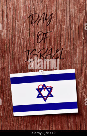 Il testo giorno di Israele e una bandiera israeliana con un cuore disegnato in essa riposte con un push-pin a un rustico sfondo di legno Foto Stock