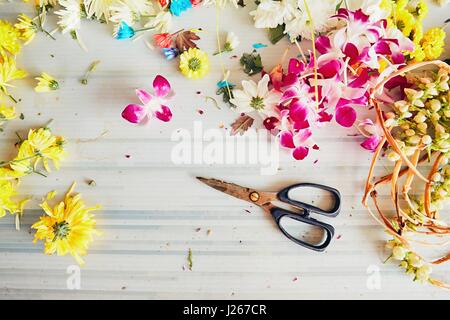 Forbici sul tavolo nel negozio di fiori - fare ghirlande di fiori per cerimonia religiosa Indù Foto Stock