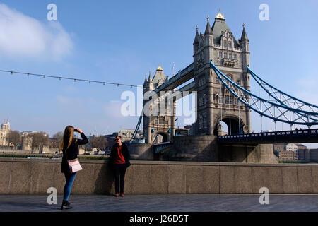 Tourist scattare una foto di un amico nella parte anteriore del Tower Bridge, London, England, Regno Unito, Europa Foto Stock