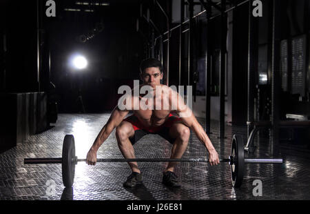 Uomo muscolare facendo il crossfit esercizio in palestra. Foto Stock