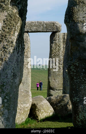 Due persone che visitano il sito di Stonehenge monumento preistorico nel Wiltshire, Inghilterra Foto Stock