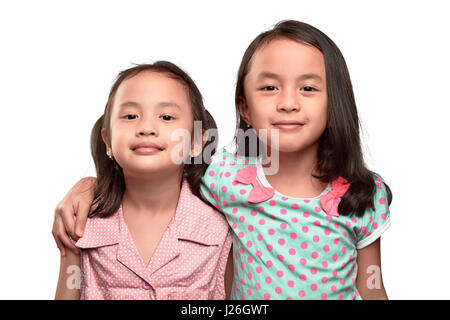 Felice due asian bambina abbracciando e divertirsi isolate su sfondo bianco Foto Stock